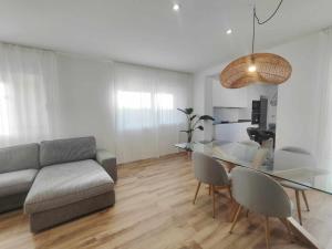 a living room with a glass table and a couch at Mazi Apartments Cuba in Mataró