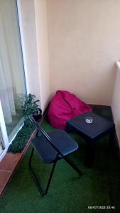 um quarto com uma cadeira e uma almofada vermelha ao lado de uma mesa em Natural House em Constança