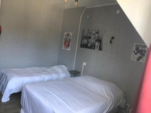 two beds in a room with posters on the wall at L'Ambroisie in Pont-d'Ouilly