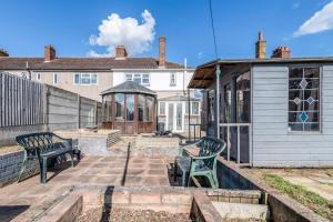 a patio with two benches and a gazebo at 3-Bed House Near Lakeside Mall, Onsite Parking in Grays Thurrock