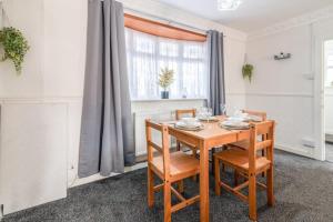 a dining room with a wooden table and chairs at 3-Bed House Near Lakeside Mall, Onsite Parking in Grays Thurrock