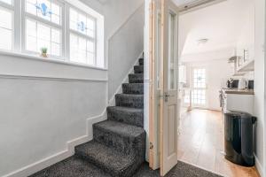 a staircase in a home with white walls and windows at 3-Bed House Near Lakeside Mall, Onsite Parking in Grays Thurrock