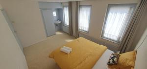 a small room with a yellow bed and a sink at Sunset de Luz in Nijmegen