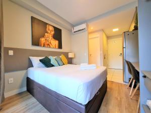 a bedroom with a large white bed in a room at Studio Benê em Pinheiros. in Sao Paulo