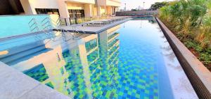 a large swimming pool with blue and green at Studio Benê em Pinheiros. in Sao Paulo