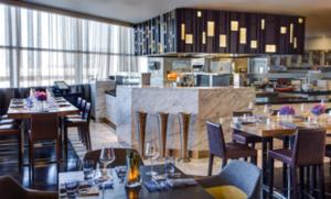een restaurant met tafels en stoelen en een keuken bij Grand Hyatt DFW Airport in Irving