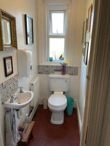 a bathroom with a toilet and a sink and a window at Maisonette - Halfway down to Swanage or up to Durlston in Swanage