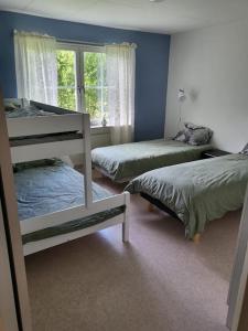 a bedroom with two bunk beds and a window at Stugby Marieke - Skärvången in Föllinge