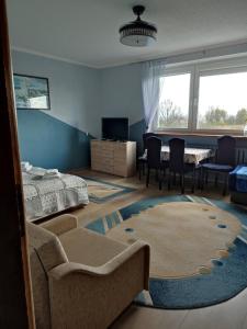 a bedroom with a bed and a living room at FitoSfera Inez in Jastarnia