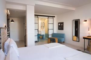 sypialnia z białym łóżkiem i niebieskim krzesłem w obiekcie 7 Islas Hotel w Madrycie