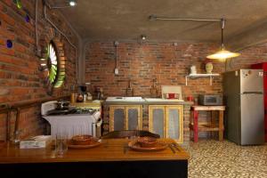 uma cozinha com uma parede de tijolos e um fogão e frigorífico em Bella Casita em Querétaro