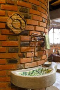 uma parede de tijolos com um lavatório de pedra num quarto em Bella Casita em Querétaro