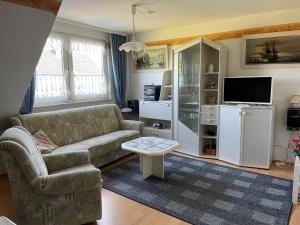 uma sala de estar com um sofá e uma televisão em Haus Mariechen em Hooksiel