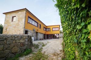 eine Außenansicht eines Hauses mit einer Steinmauer in der Unterkunft Casa do Ribeiro in Lago