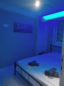 a bedroom with a bed with blue lights on it at Andromeda in Paralia Katerinis