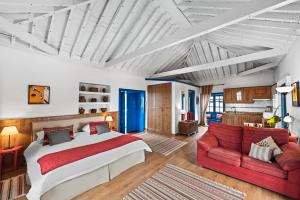 プエルト・デ・ラ・クルスにあるLa Hacienda Grandeのベッドルーム1室(ベッド1台、赤いソファ付)