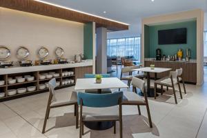 a restaurant with tables and chairs and a counter at Fairfield by Marriott San Jose Airport Alajuela in Alajuela City
