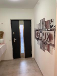 a hallway with a black door and a sign that reads home at Rhein Appartements in Rheinhausen