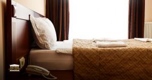 a bed with two towels on it in a bedroom at Hotel Parlament in Pristina