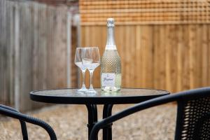 uma garrafa de vinho e dois copos numa mesa em Mill Dam Lake House em Saint Osyth