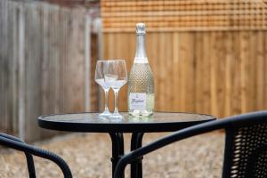 Una botella de vino y dos copas en una mesa en Mill Dam Lake House, en Saint Osyth