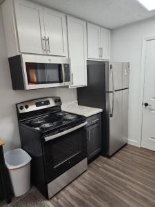 a kitchen with a stove and a microwave and a refrigerator at Miami Gallery Private Queen Bedroom and Shared Bathroom in Oxford