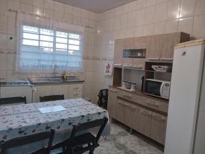 una pequeña cocina con mesa y nevera en Pousada Alvinópolis en Atibaia