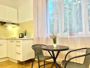 uma cozinha com mesa e cadeiras e uma janela em K22 Park Lazienki Aparts in Warsaw em Varsóvia
