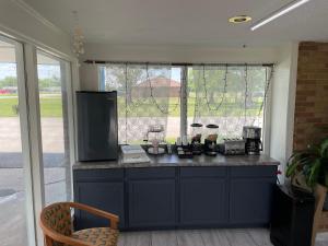 a kitchen with a blue counter with a window at Rodeway Inn in Flora