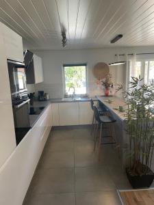 a kitchen with white cabinets and a counter with a plant at Sentralt beliggende moderne leilighet in Mosjøen