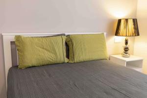 a bed with two green pillows and a lamp at Luxury cozy appartment in the city center in Rhodes Town