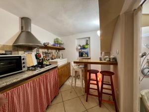 une cuisine avec un comptoir et deux tabourets de bar dans l'établissement Living Dalia, à Carovigno