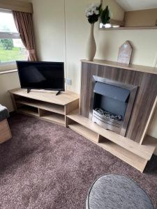 a living room with a television and a fireplace at Golden Palm Resort, Sherwood Plot, Jubilee S216, 8 Berth in Chapel Saint Leonards
