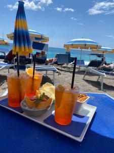 una bandeja de bebidas en una mesa en la playa en Beach Penthouse Marisol 2Floors, central, en Letojanni