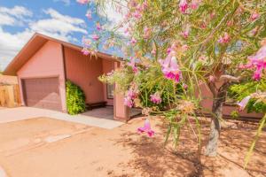 a house with a tree with pink flowers in front of it at Newly Remodeled Family Friendly Home in Page