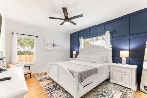 - une chambre avec un lit blanc et des murs bleus dans l'établissement Serenity Pearl Escape, à Saint Augustine