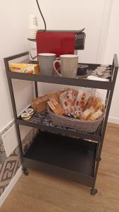 une étagère avec un panier de pain et des tasses dessus dans l'établissement MAISON VENTIMIGLIA 83, à Catane