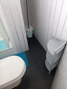 a bathroom with a white toilet and a window at Chalet 281 Golden Sands Holiday Park in Withernsea