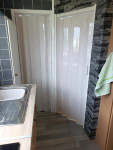 a bathroom with a sink and a door at Chalet 281 Golden Sands Holiday Park in Withernsea
