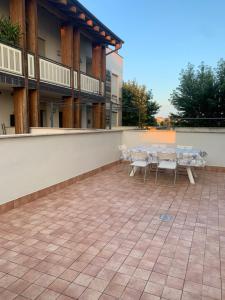 un patio avec des tables et des chaises dans un bâtiment dans l'établissement MAX’S RESIDENCE, à Montegrotto Terme