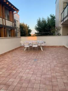 - une terrasse avec une table et des chaises dans un bâtiment dans l'établissement MAX’S RESIDENCE, à Montegrotto Terme