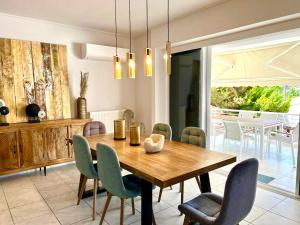 a dining room with a wooden table and chairs at Sea, La Vie in Saronida