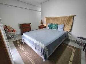 um quarto com uma cama grande e uma mesa de cabeceira em Apto Astúrias Guarujá no Guarujá