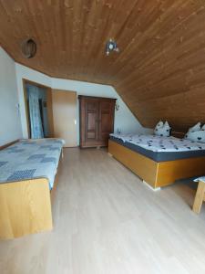 a bedroom with two beds and a wooden ceiling at tAllhouse in Eggolsheim