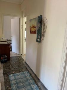 um corredor com uma parede branca e uma imagem na parede em Nectarios seaside apartment. em PalaiónTsiflíkion