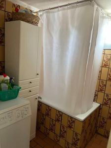 Una cocina con una cortina de ducha blanca en una cocina. en Nectarios seaside apartment., en Palaión Tsiflíkion 11 fotos más