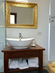 a bathroom with a white sink and a mirror at L'Araucaria Suite Il Ginepro in Riola Sardo