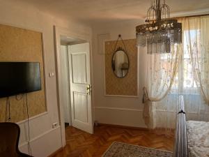 a bedroom with a chandelier and a door with a window at Apartment Hisa 7 Piran in Piran