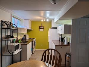 cocina con paredes amarillas y nevera blanca en logement,suite l arlequin en Vaudreuil-Dorion