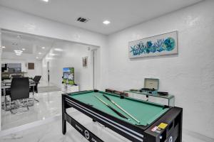 a living room with a pool table in it at The Lake House in Fort Lauderdale in Fort Lauderdale